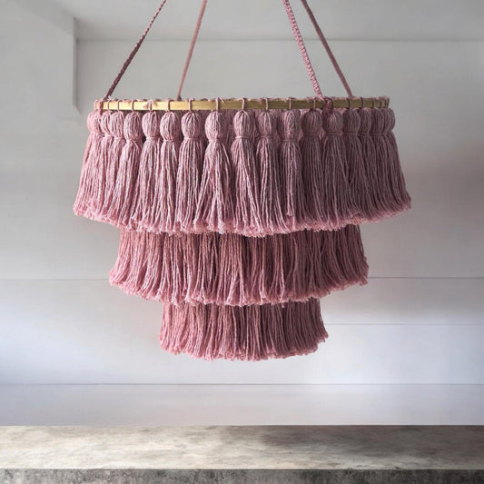 Handmade layered macrame chandelier with tassels in soft purple tones, made of natural cotton. This bohemian inspired ceiling light adds a fun yet elegant touch to any room, perfect for creating a cozy and unique atmosphere. Ideal for nursery rooms.