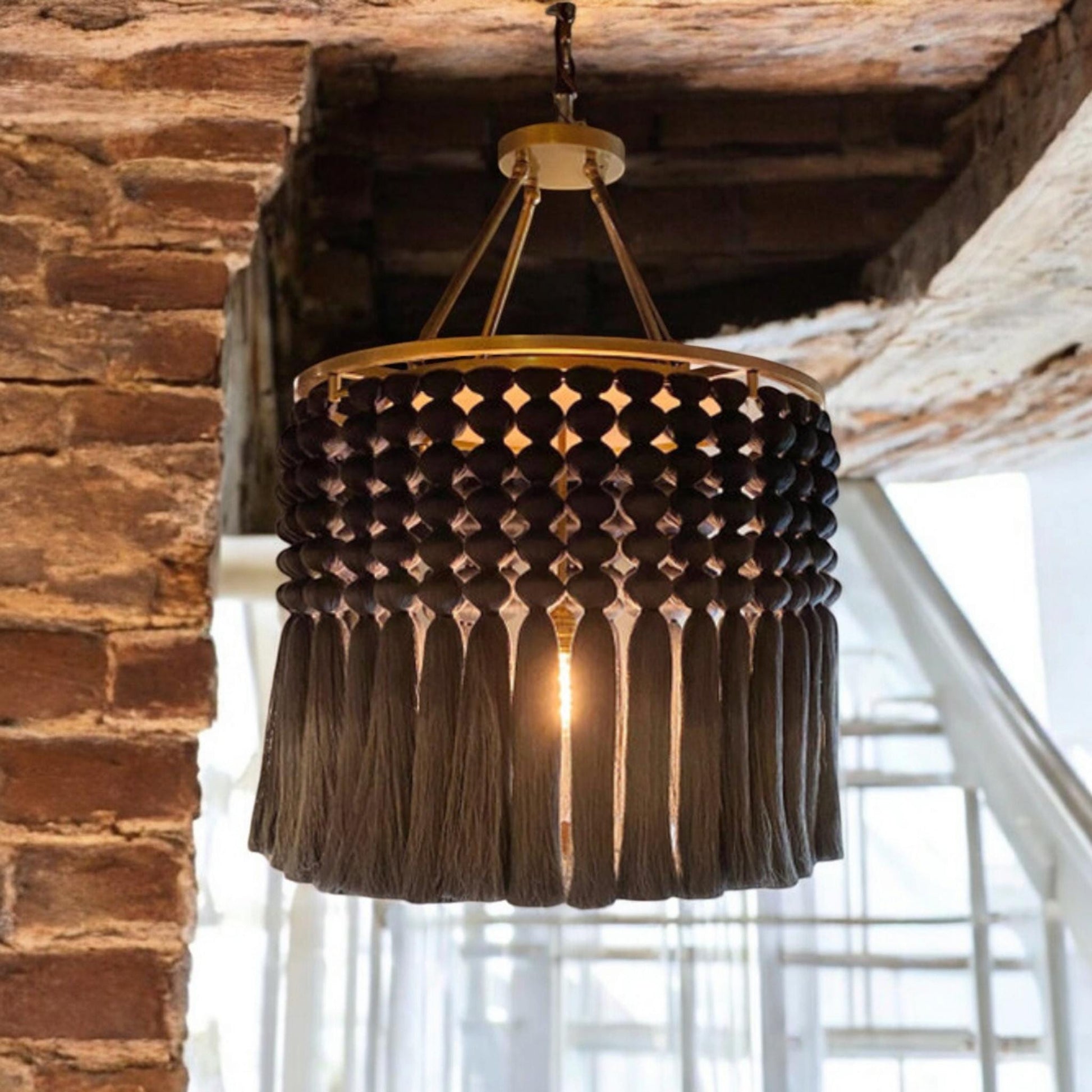 handmade, modern, and elegant black macrame chandelier. with a diameter 75cm, this chandelier is ideal for creating a warm and stylish atmosphere indoors.Featuring gold detalis and aunique weaving technique, it fits perfectly with industrial styles.
